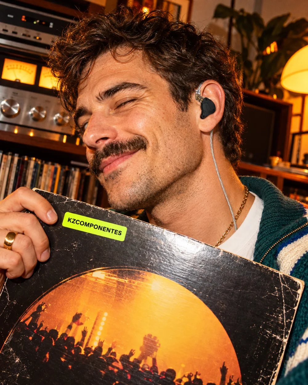Hombre con auriculares KZ Hi-Fi enseñando un vinilo