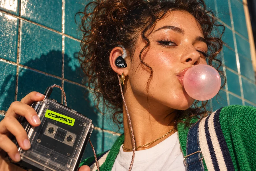 Chica con auriculares KZ haciendo una pompa de chicle